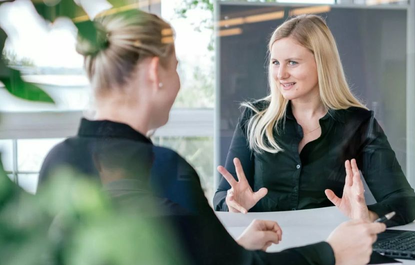 Zwei Mitarbeiterinnen einer Social-Media-Agentur sitzen in einem Beratungsgespräch und planen Kampagnen für Social-Media-Marketing – unterstreicht die enge Zusammenarbeit mit einem vertrauenswürdigen Social-Media-Partner.